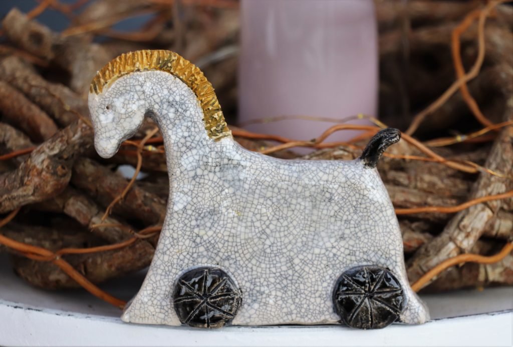 graues Pferd mit hellbrauner Mähne und schwarzen Kreisen bei den Füßen
